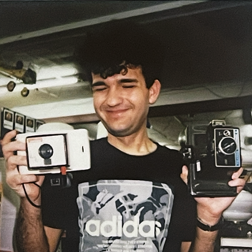 John holding ancient Polaroids